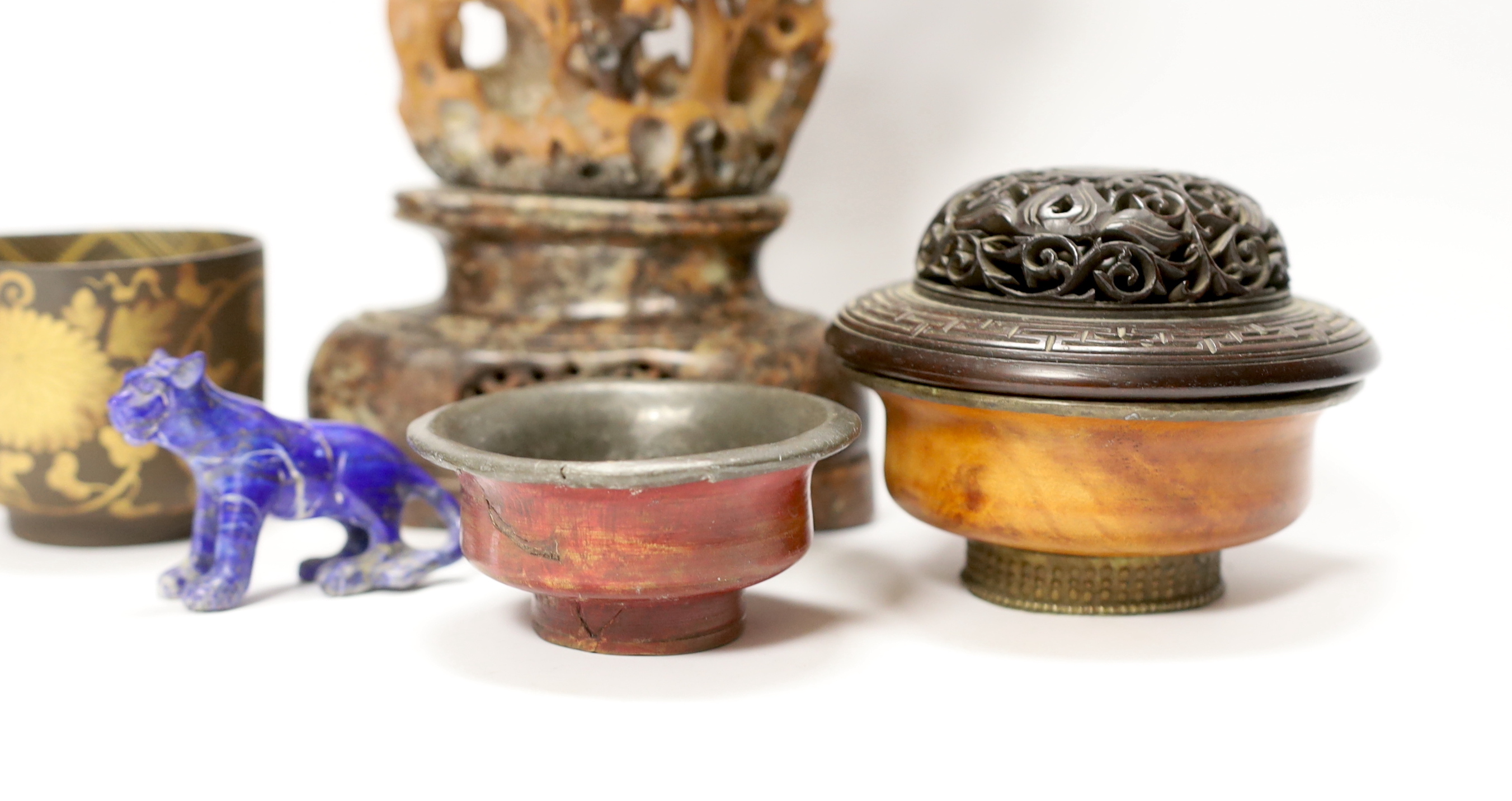 A Chinese carved hardwood cover, a soapstone carving, 27.5cm high, a lapis lazuli model of a tiger, a bronze teacup and two pewter and wood tea bowls (7)